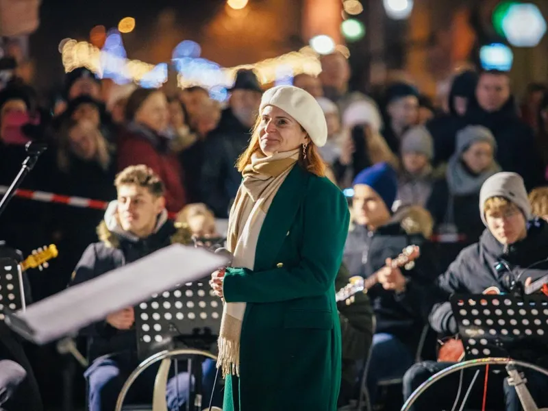 Voditeljica programa i publika na Božićnom koncertu na prozorima Gimnazije u Vinkovcima
